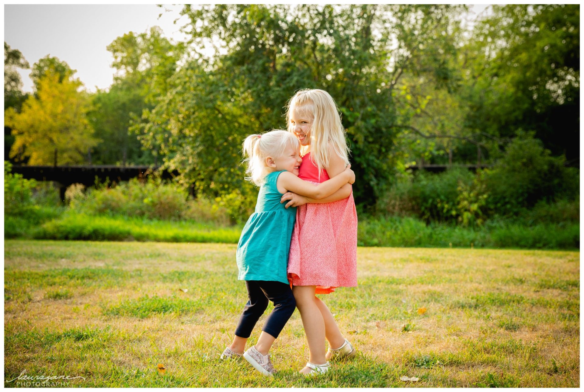 Candid photo of sisters hugging near Fox river